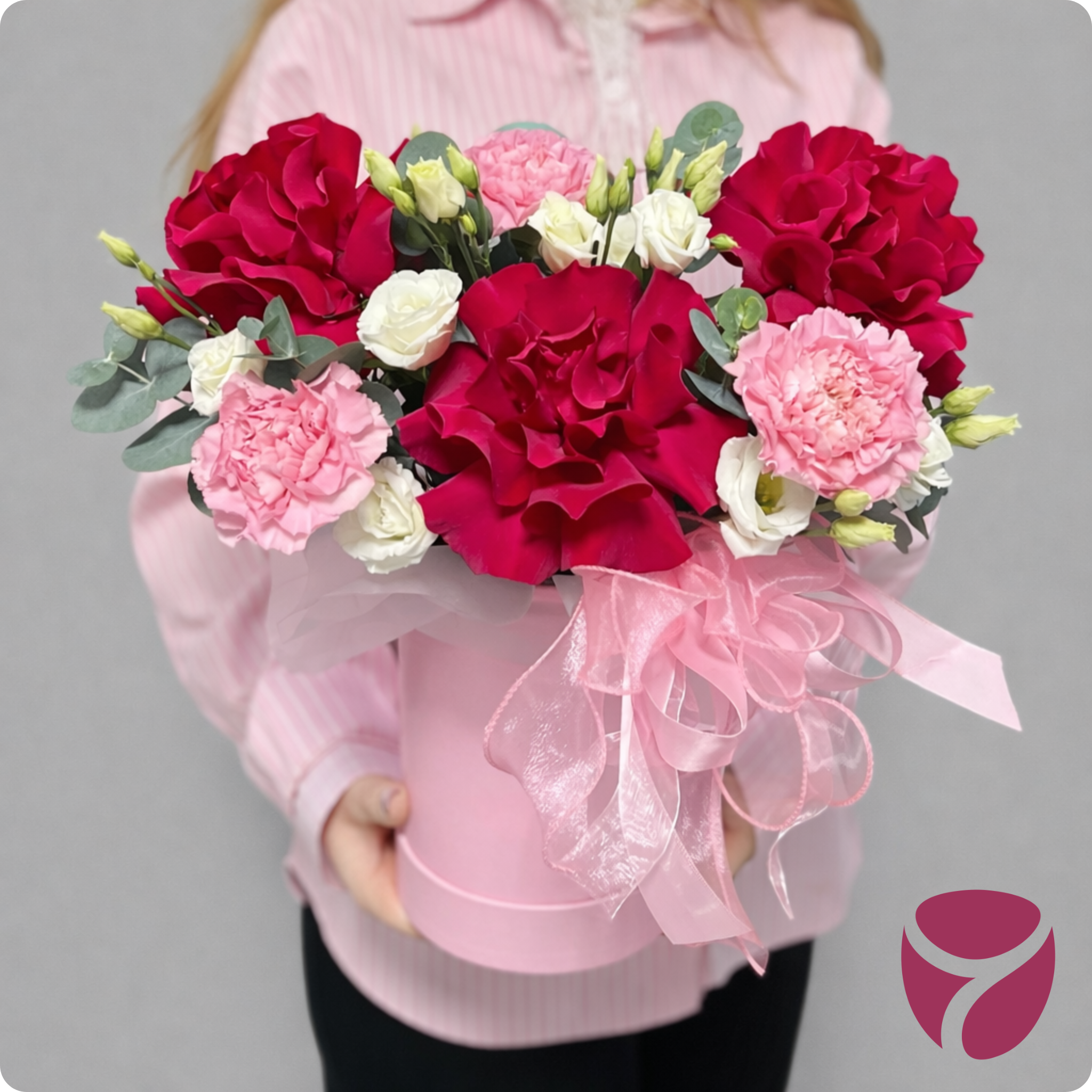 Девушка держит в руках французские розы в коробке с эустомой и диантусами