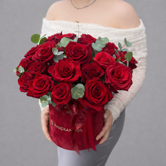 Композиция из алых роз с эвкалиптом в красной коробке