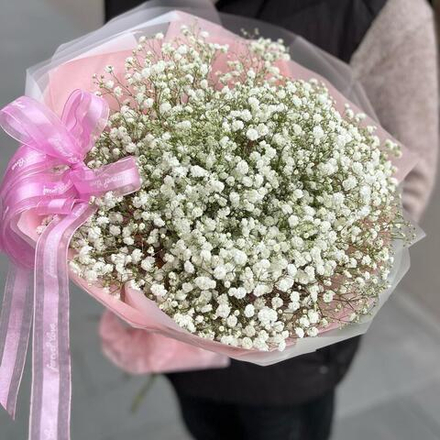 Букет из белой гипсофилы в розовой упаковке с бантом